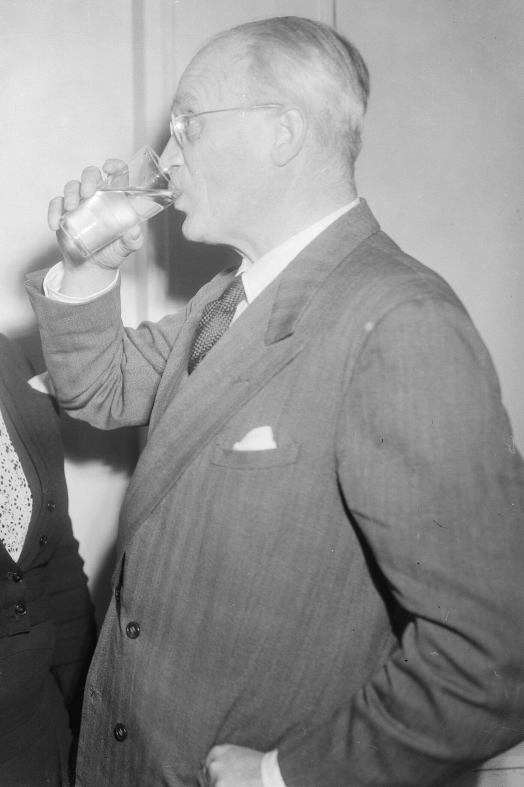 man drinkt een glas water bij een jubileum